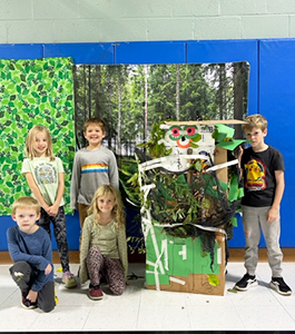 Group of happy students next to a forest project